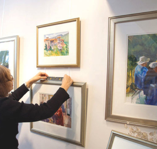 Woman hanging a work of art